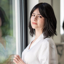 Load image into Gallery viewer, Woman wearing the "Harper" wig, by la Vida. She  is wearing a white robe standing by a window.