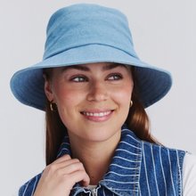 Load image into Gallery viewer, Woman wearing a blue bucket hat against a white background